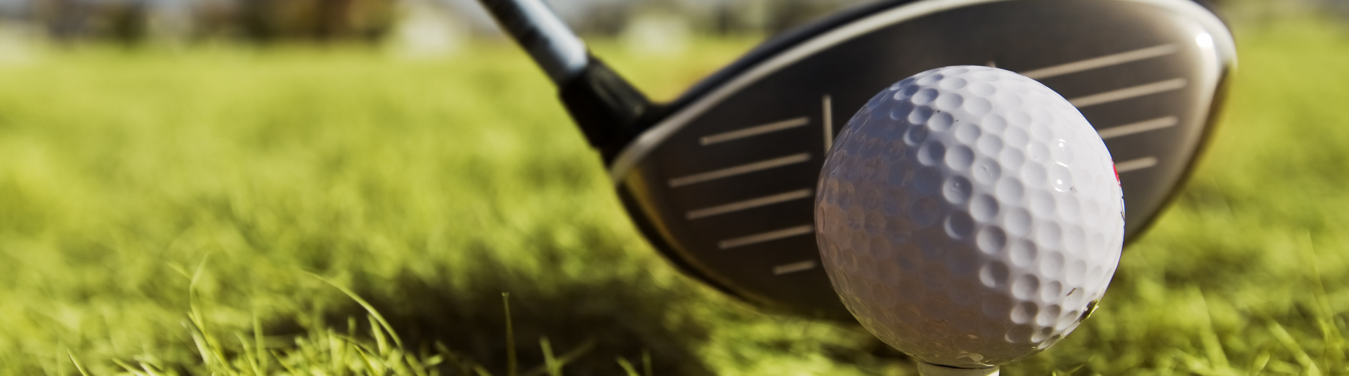 close up of golf club against golf ball